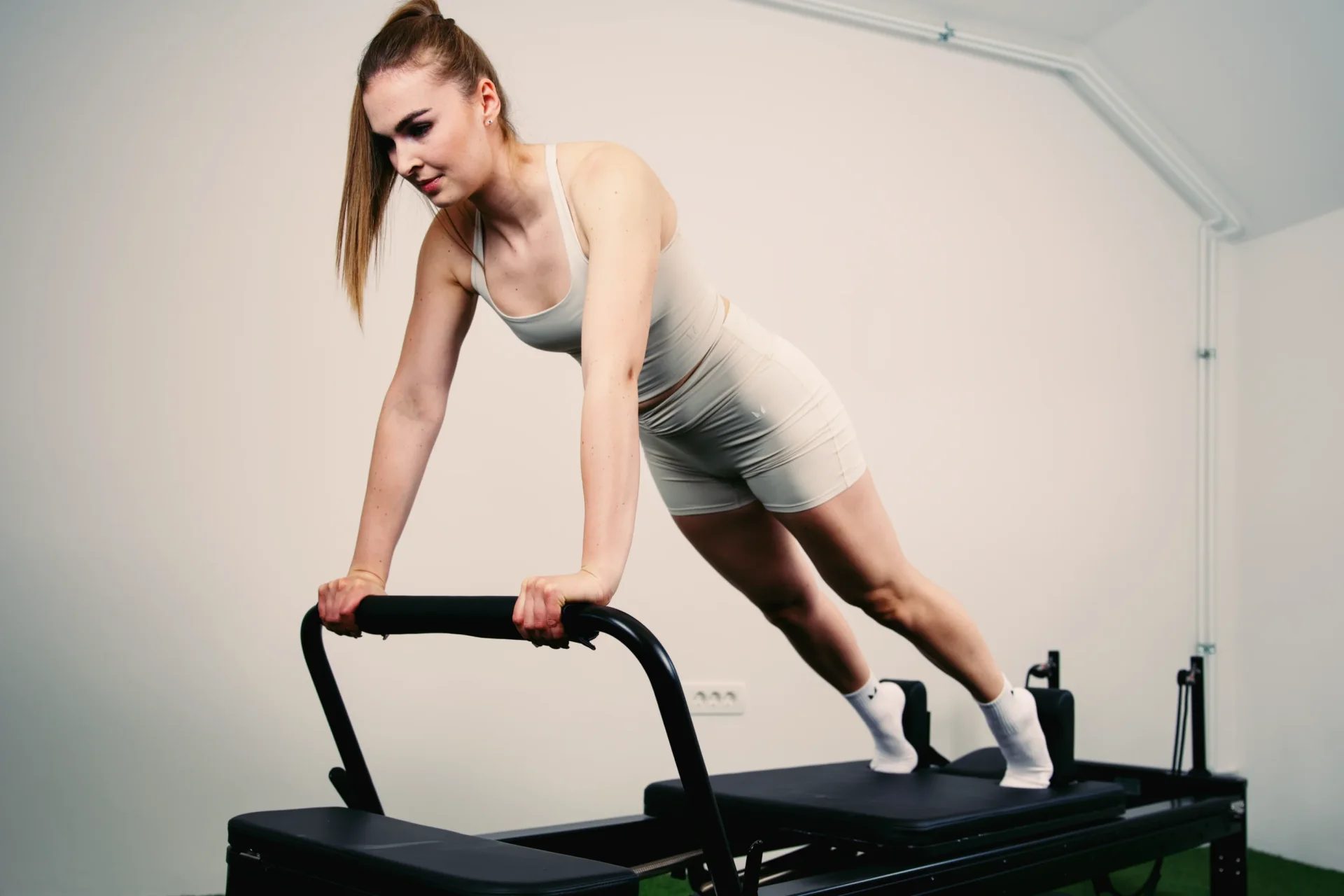 Pilates reformer Toorx Liveness u svijetlom studiju — vježba za pokretljivost i snagu
